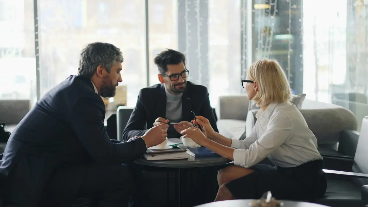 Reunión de tres profesionales en una oficina luminosa