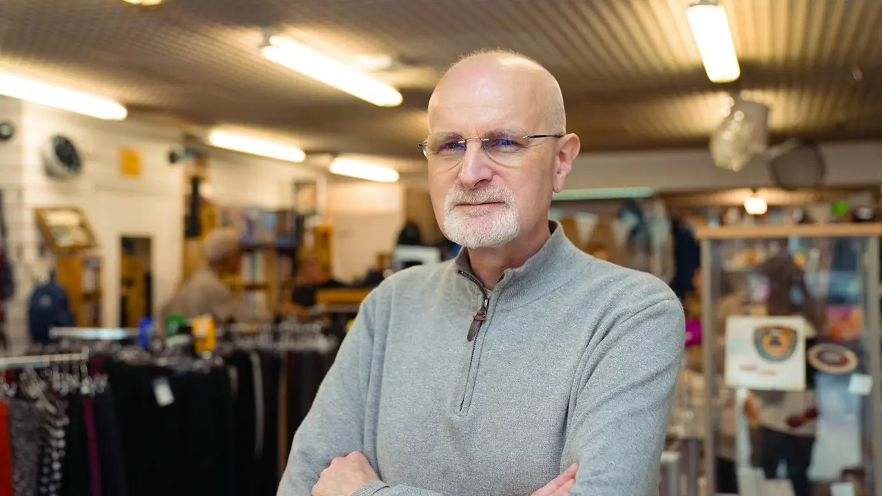 El dueño de una tienda posa entre los estantes de su comercio